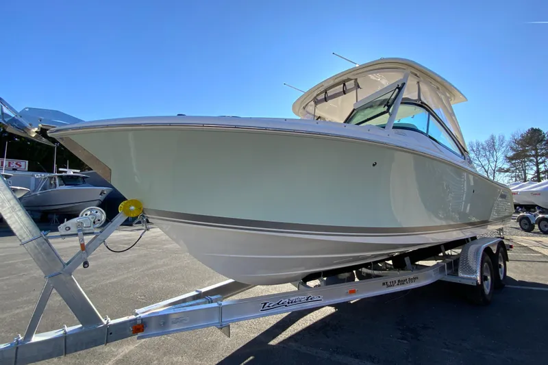 Slide: The Image of 2026 Pursuit DC 246 Dual Console boat on trailer under clear blue sky. - 5