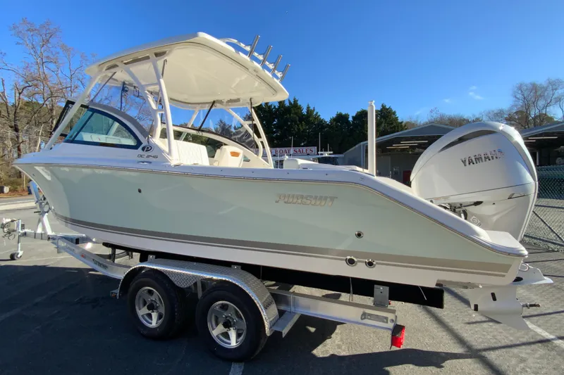 Slide: The Image of 2026 Pursuit DC 246 Dual Console boat on trailer, featuring Yamaha engine, outdoors. - 7