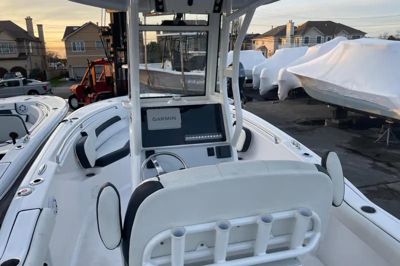 Slide: The Image of 2024 Tidewater 232 CC Adventure boat with Garmin navigation, docked outdoors. - 4