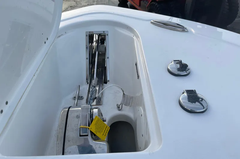 Slide: The Image of 2024 Tidewater 232 CC Adventure boat anchor compartment with chrome fittings. - 6