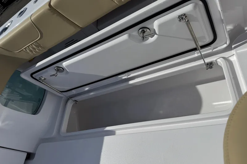 Slide: The Image of Open storage compartment on 2026 Phenom 37 Center Console boat, featuring beige seating. - 17