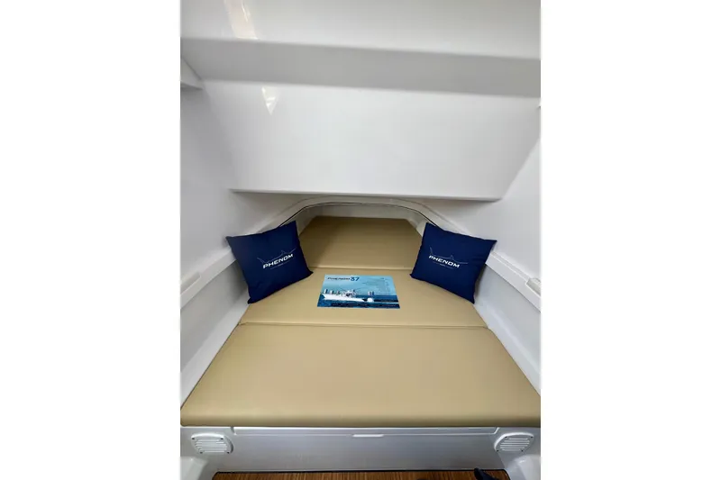 Slide: The Image of Interior cabin of 2026 Phenom 37 Center Console with cushions and brochure. - 27