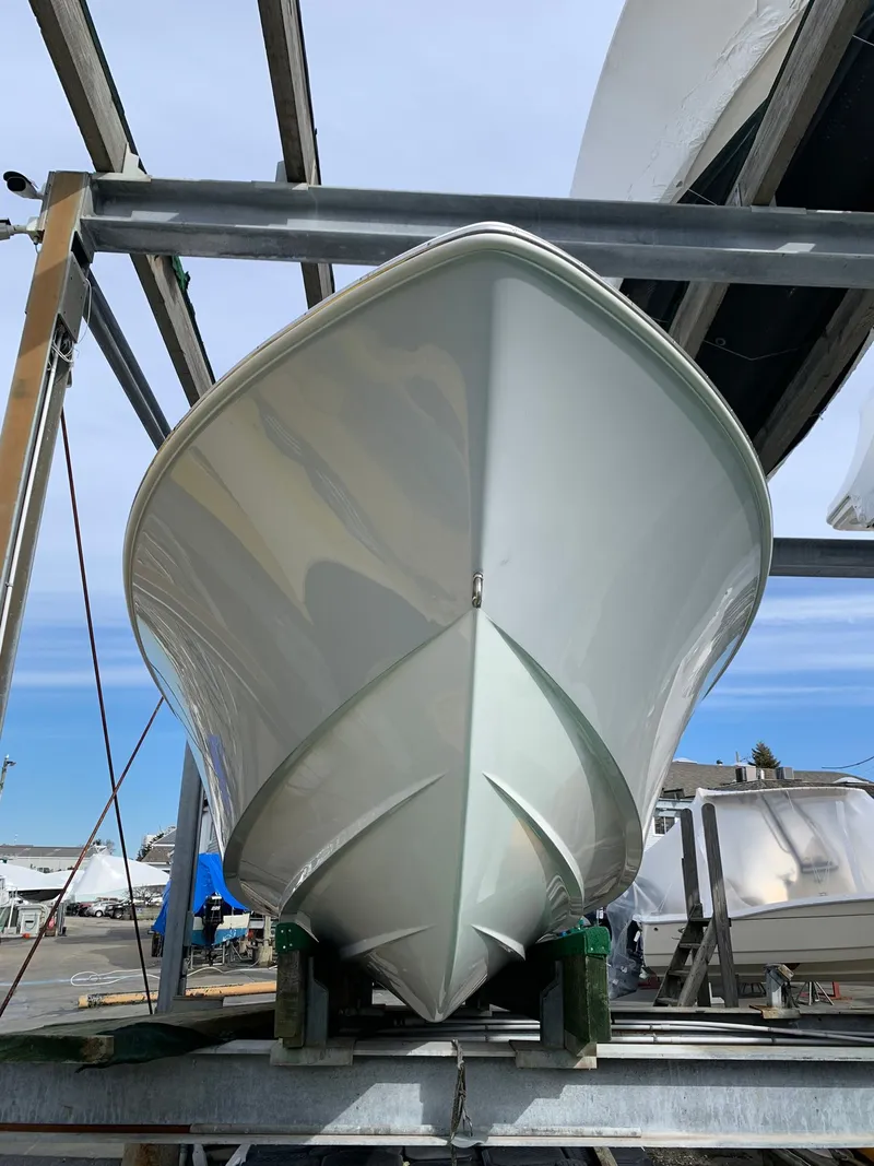 Slide: The Image of 2026 Contender 25 T boat on a lift, showcasing sleek hull design. - 2