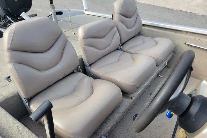 Slide: The Image of 2002 Tracker Pro Team 175 boat interior with beige seats and steering wheel. - 13
