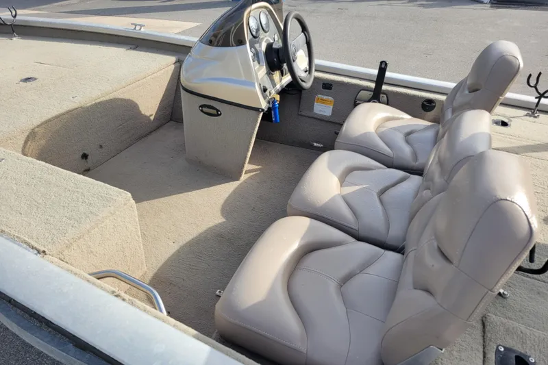 Slide: The Image of 2002 Tracker Pro Team 175 boat interior with beige seats and steering console. - 8
