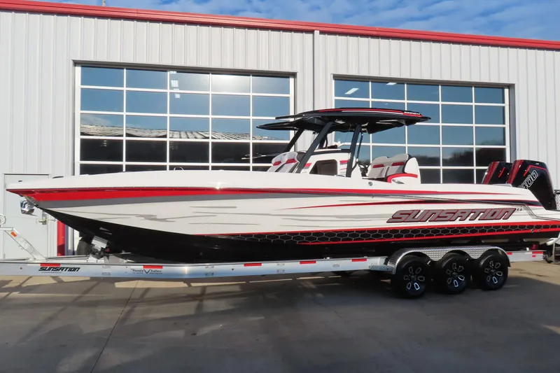 The Image of 2026 Sunsation 32 CCX boat on trailer, sleek design, red and white color scheme. - 0