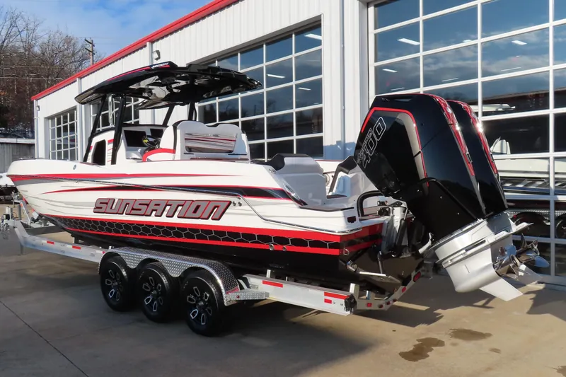 Slide: The Image of 2026 Sunsation 32 CCX boat with powerful outboard engines, parked outside a showroom. - 3