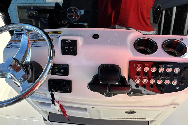 Slide: The Image of Control panel of 2023 NauticStar 28 XS boat with steering wheel and switches. - 10