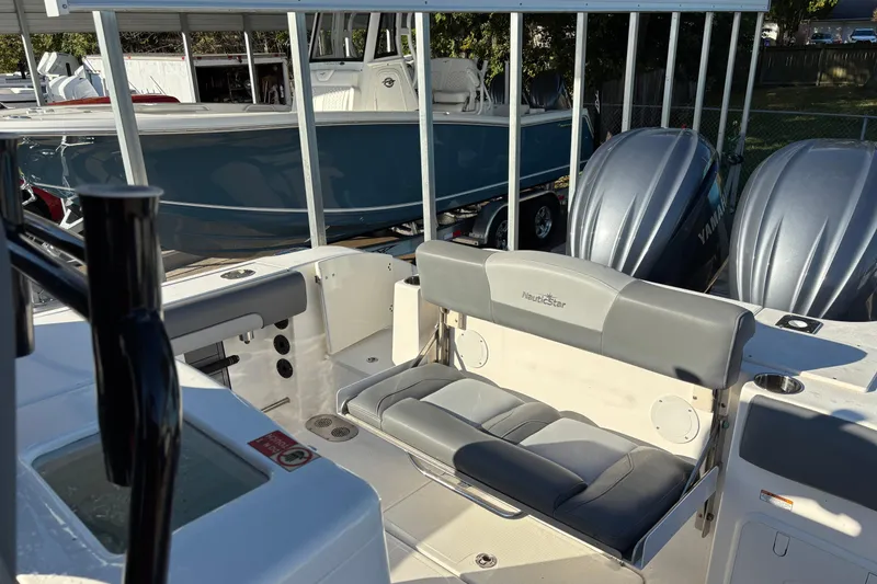 Slide: The Image of 2023 NauticStar 28 XS boat interior with seating and dual Yamaha engines. - 12