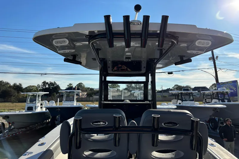 Slide: The Image of 2023 NauticStar 28 XS boat with T-top and rod holders, displayed outdoors. - 15