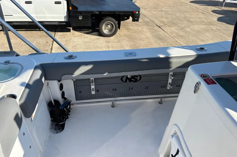 Slide: The Image of 2023 NauticStar 28 XS boat interior with measuring board and storage compartments. - 16
