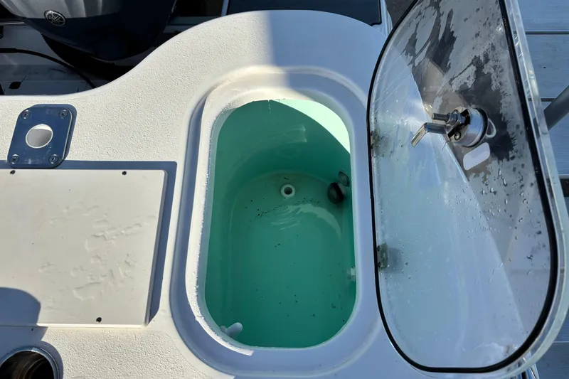 Slide: The Image of Livewell on 2023 NauticStar 28 XS boat, open lid, showing interior. - 18