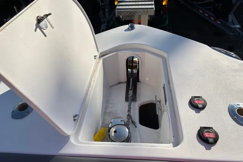 Slide: The Image of Open anchor compartment on 2023 NauticStar 28 XS boat, showing chain and winch. - 19