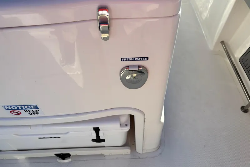 Slide: The Image of 2023 NauticStar 28 XS boat interior with fresh water access and safety notice. - 21