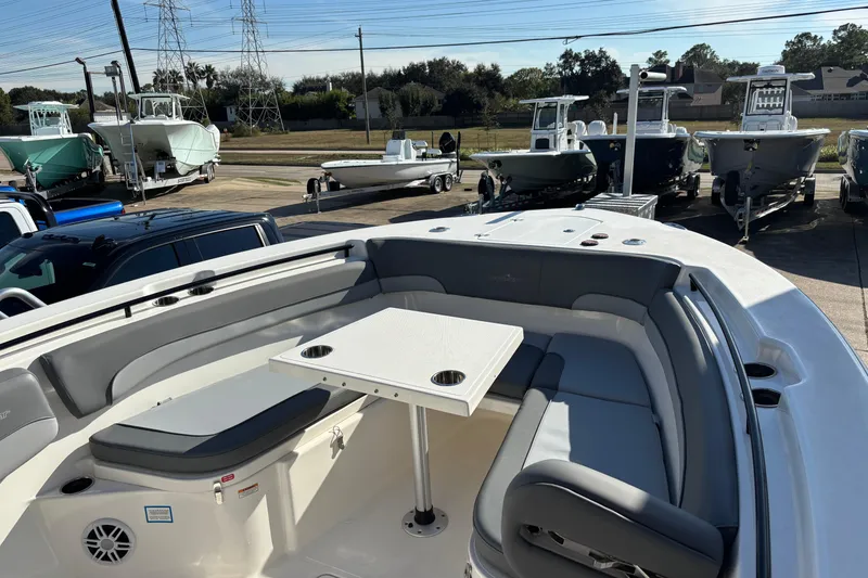 Slide: The Image of 2023 NauticStar 28 XS boat with spacious seating and table, parked in a marina. - 4