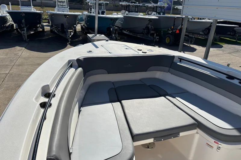 Slide: The Image of 2023 NauticStar 28 XS boat interior with cushioned seating in a showroom. - 5