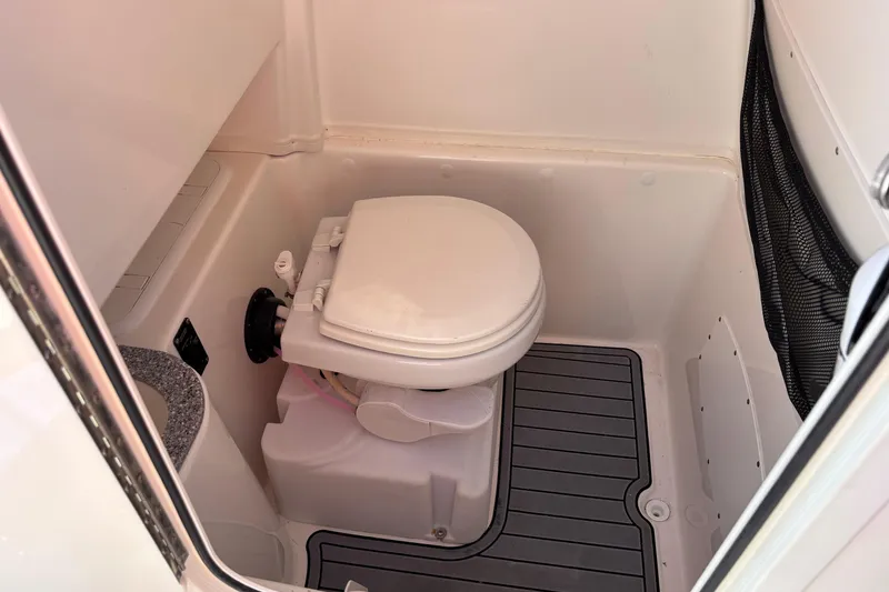 Slide: The Image of 2023 NauticStar 28 XS boat interior with compact marine toilet. - 7