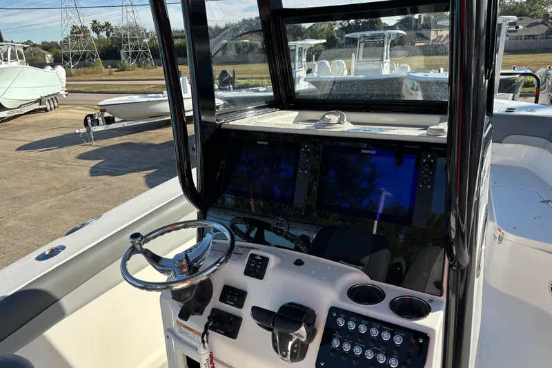 Slide: The Image of 2023 NauticStar 28 XS boat dashboard with dual Simrad displays and steering wheel. - 9
