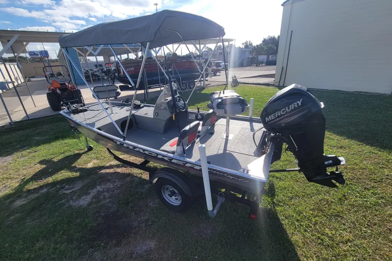 Slide: The Image of 2016 Tracker Pro 160 boat with Mercury outboard motor, parked outdoors. - 4