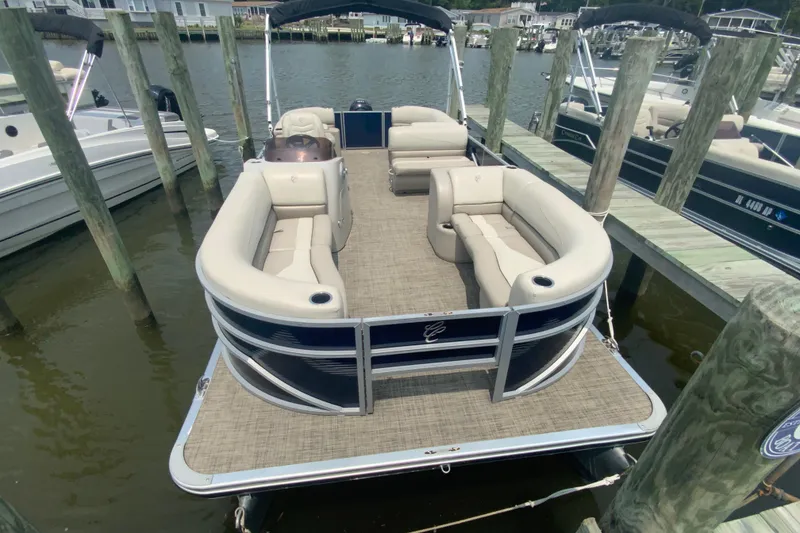 Slide: The Image of 2023 Cypress Cay Seabreeze 232 pontoon boat docked, featuring spacious seating and modern design. - 2