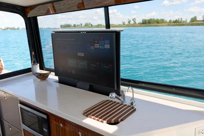 Slide: The Image of Luxury interior of 2026 MJM 47X yacht with TV, sink, and scenic water view. - 12