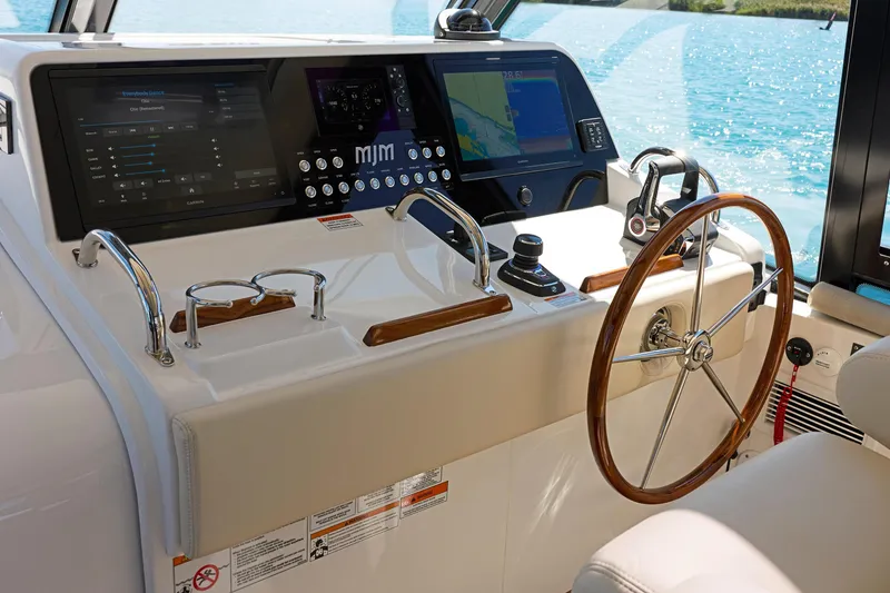 Slide: The Image of Helm of 2026 MJM 47X yacht with advanced navigation controls and wooden steering wheel. - 3
