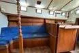 Slide: The Image of 1974 Colvin Gazelle Custom boat cabin with blue bedding and wooden interior. - 11