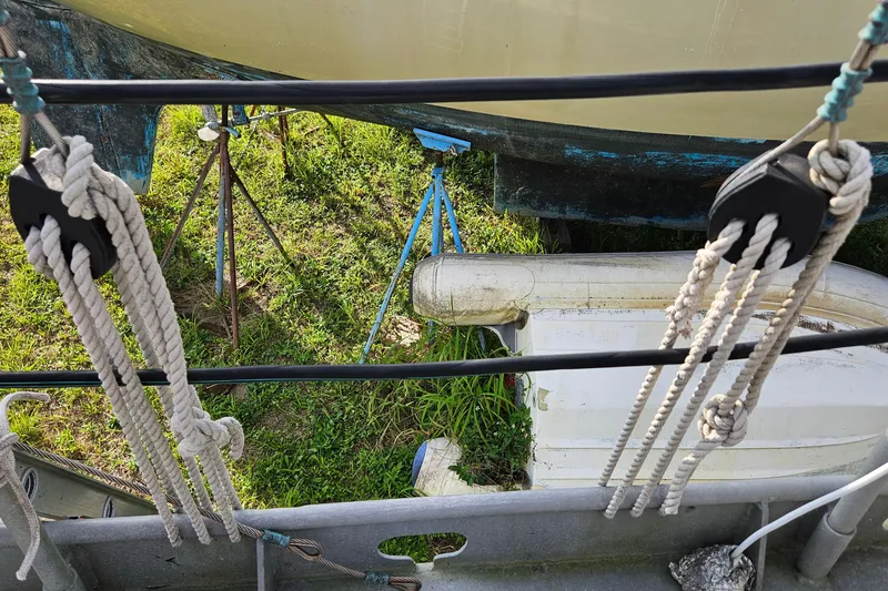 Slide: The Image of Ropes and pulleys on a 1974 Colvin Gazelle Custom boat, with grass and equipment below. - 22