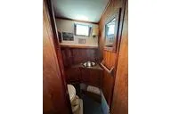 Slide: The Image of Interior of a 1974 Colvin Gazelle Custom boat with a wooden desk and storage. - 6