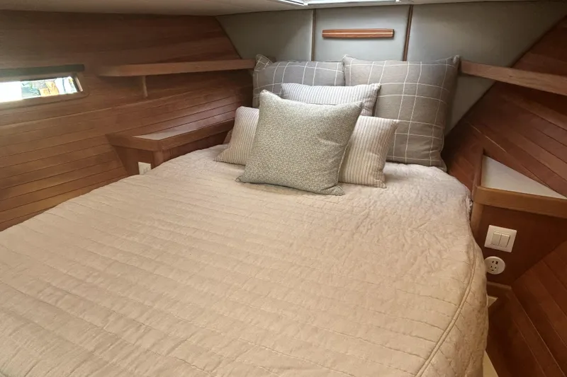 Slide: The Image of Cozy cabin interior of 2026 MJM 47R yacht with plush bedding and wooden accents. - 6