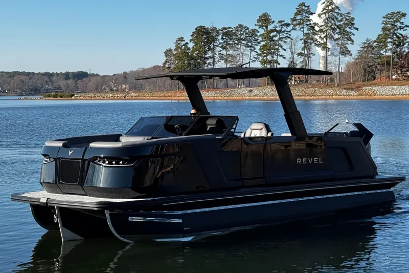 Slide: The Image of 2026 Revel RS25L luxury boat on a serene lake with trees in the background. - 10