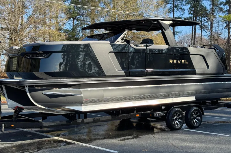 Slide: The Image of 2026 Revel RS25L luxury boat on trailer, sleek black design, parked outdoors. - 22