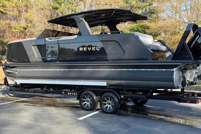 Slide: The Image of 2026 Revel RS25L luxury pontoon boat on trailer, featuring sleek black design and modern amenities. - 24