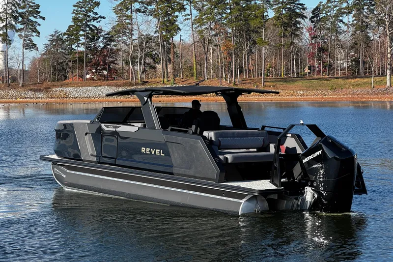 Slide: The Image of 2026 Revel RS25L boat cruising on a serene lake with trees in the background. - 5