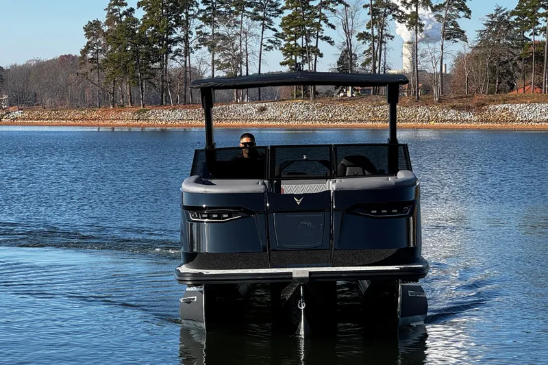Slide: The Image of 2026 Revel RS25L pontoon boat cruising on a serene lake with trees in the background. - 9