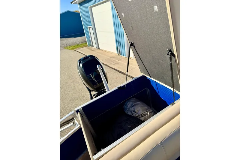 Slide: The Image of 2012 Regency Sun Tracker Party Barge with open storage compartment and outboard motor. - 36