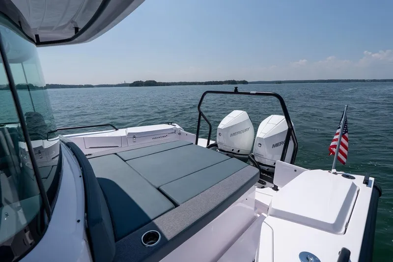 Slide: The Image of 2026 Axopar 37 XC boat with twin Mercury engines on a calm lake. - 16