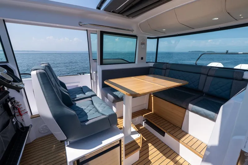 Slide: The Image of Interior of 2026 Axopar 37 XC boat with seating and wooden table, overlooking the ocean. - 39