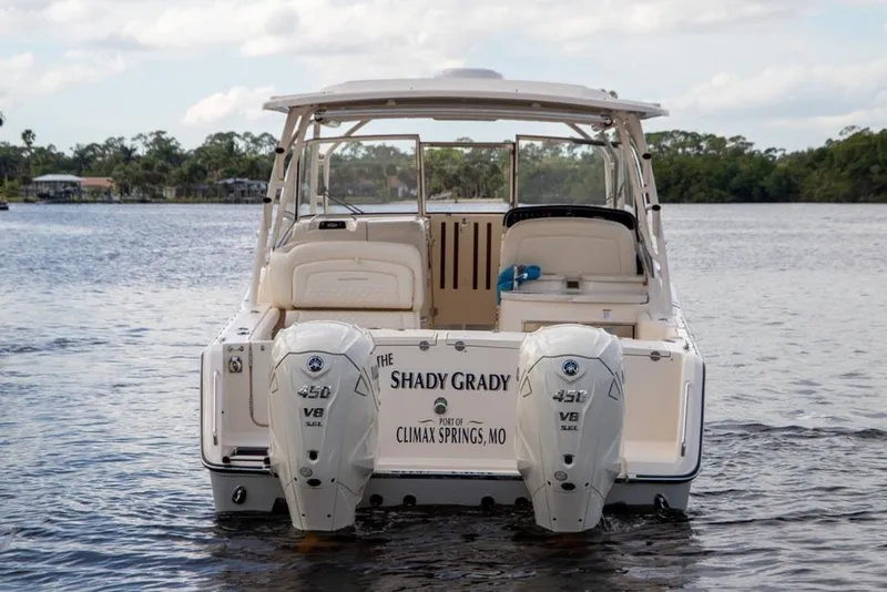 Slide: The Image of 2024 Grady-White Freedom 335 boat with twin Yamaha V8 engines on a calm lake. - 10