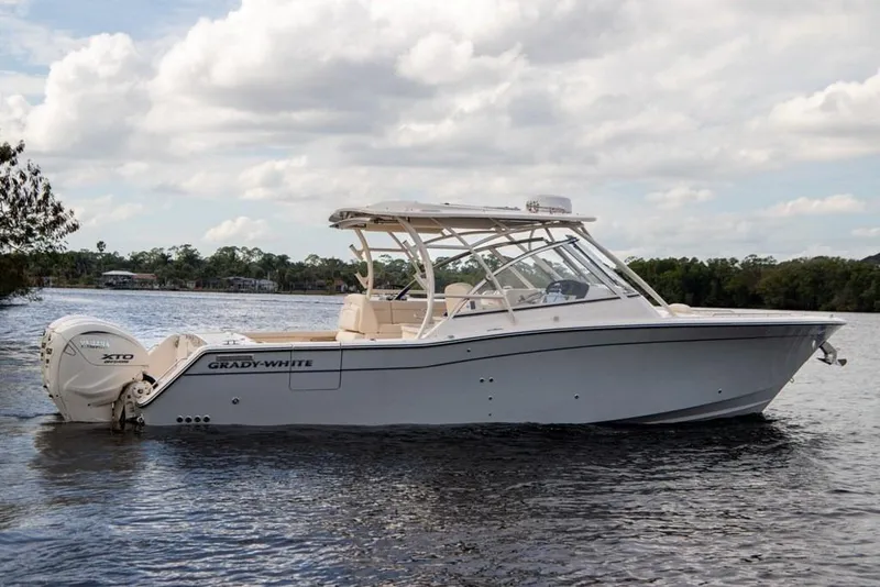 Slide: The Image of 2024 Grady-White Freedom 335 boat on calm water under cloudy sky. - 12