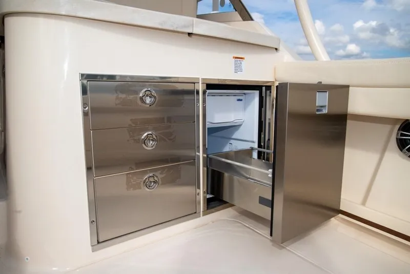 Slide: The Image of 2024 Grady-White Freedom 335 boat interior with stainless steel storage and refrigerator. - 20