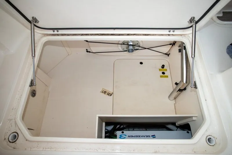 Slide: The Image of 2024 Grady-White Freedom 335 storage compartment with hydraulic supports and SeaKeeper 3 system. - 23