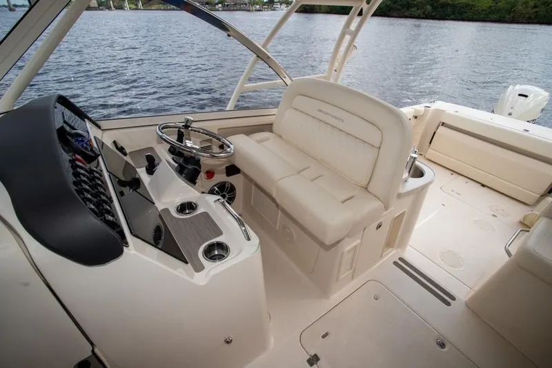 Slide: The Image of 2024 Grady-White Freedom 335 boat interior with helm and seating, on calm water. - 25