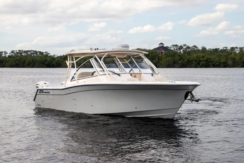 Slide: The Image of 2024 Grady-White Freedom 335 boat cruising on a calm lake under a cloudy sky. - 3