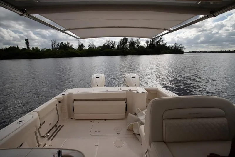 Slide: The Image of 2024 Grady-White Freedom 335 boat interior with dual engines on a calm lake. - 32