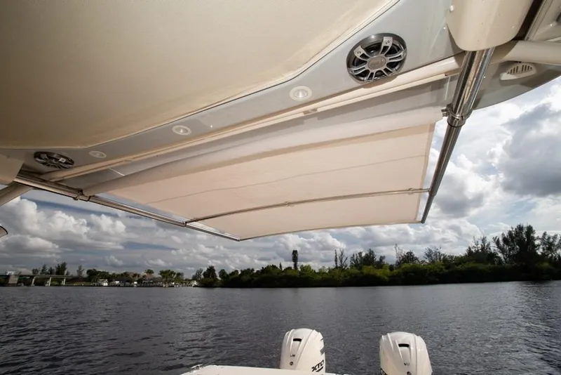 Slide: The Image of 2024 Grady-White Freedom 335 boat with retractable sunshade on a scenic waterway. - 36