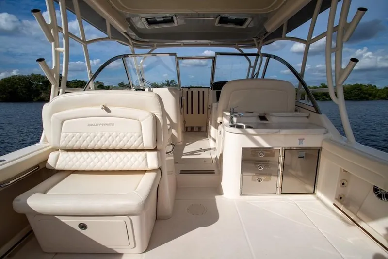 Slide: The Image of 2024 Grady-White Freedom 335 boat interior with seating and kitchenette on a sunny day. - 39