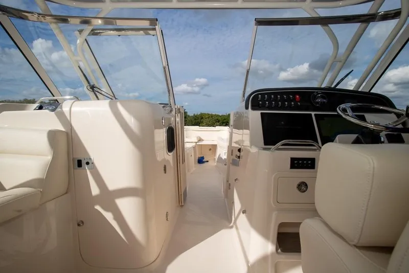 Slide: The Image of 2024 Grady-White Freedom 335 boat interior with helm and seating under blue sky. - 40
