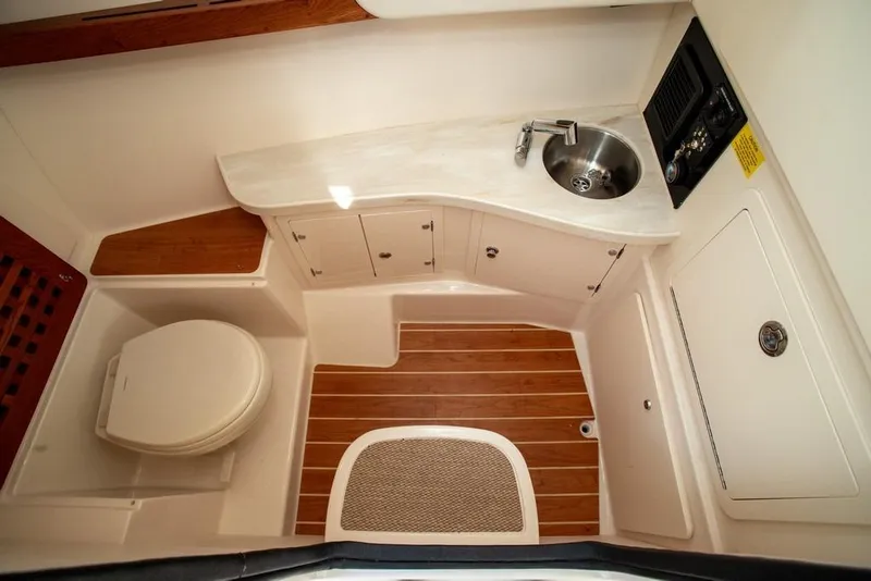 Slide: The Image of 2024 Grady-White Freedom 335 boat interior with toilet, sink, and wooden flooring. - 53