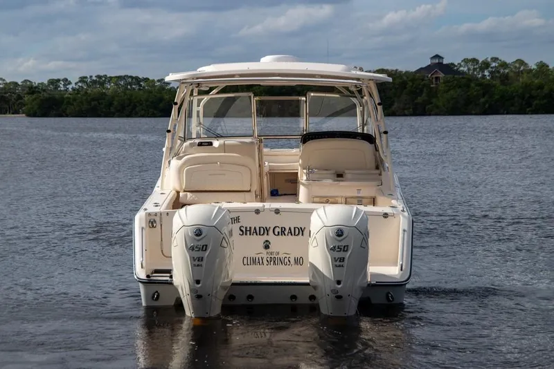 Slide: The Image of 2024 Grady-White Freedom 335 boat with twin 450 V8 engines on a calm lake. - 68